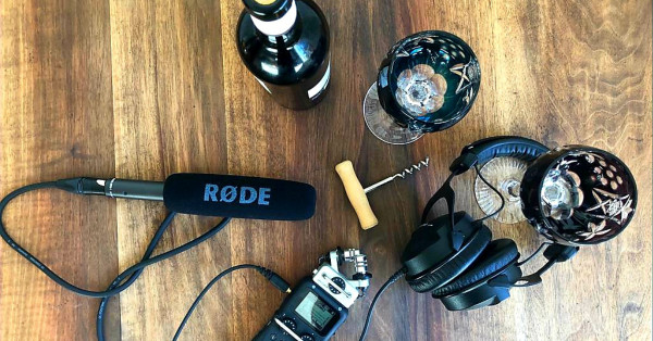 Mikrofon, umgeben von Weingläsern und Korkenzieher